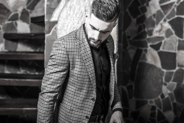 Beau jeune homme élégant pose contre l'intérieur de la maison. Portrait noir-blanc . — Photo