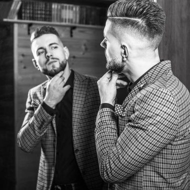 Zarif yakışıklı genç ev ayna karşı poz. Siyah-beyaz portre.