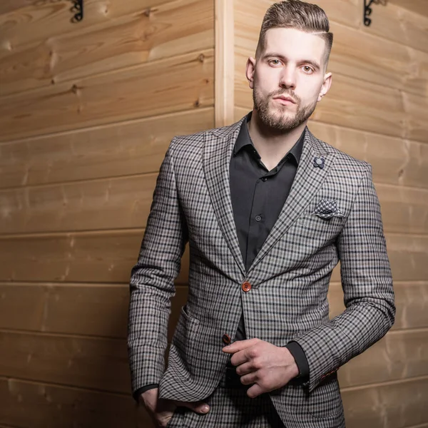 Handsome young elegant man pose against wooden background. — Stock Photo, Image