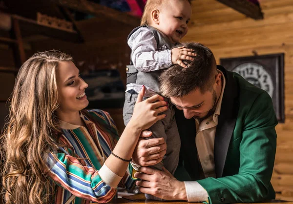 Young happy family together in interior of wooden house. — Stock Photo, Image