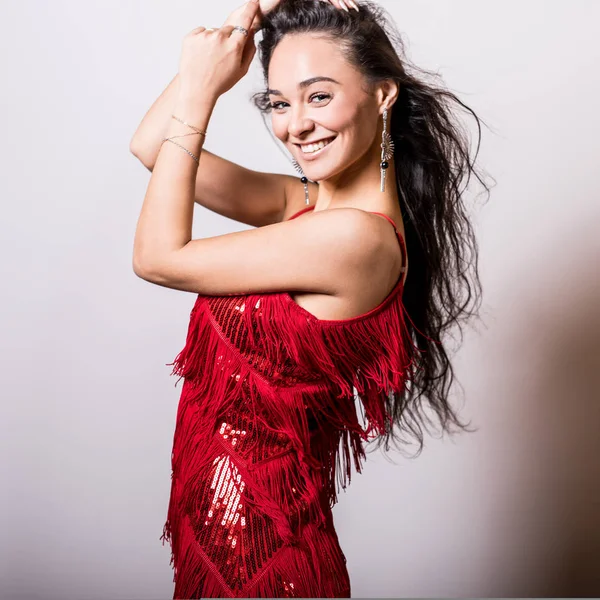 Jeune femme sensuelle en robe rouge pose en studio . — Photo