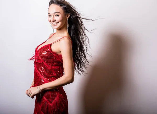 Jeune femme sensuelle en robe rouge pose en studio . — Photo
