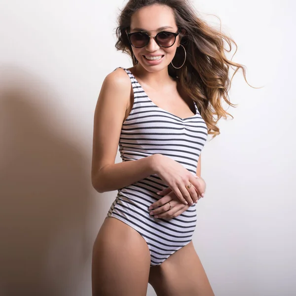 Jeune femme magnifique en maillot de bain rayé portrait studio . — Photo