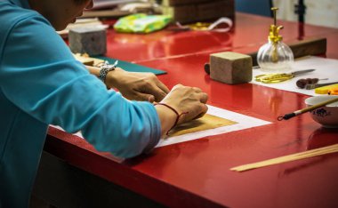 Pekin, Çin - 01 Haziran 2019: Geleneksel Çince kitap ve kaligrafi restoratörü laboratuvarı. Usta eller iş başında. Yakın plan..
