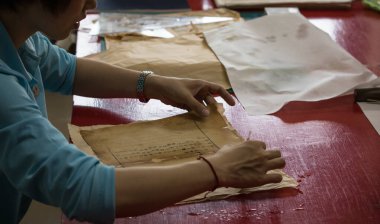 Pekin, Çin - 01 Haziran 2019: Geleneksel Çince kitap ve kaligrafi restoratörü laboratuvarı. Usta eller iş başında. Yakın plan..