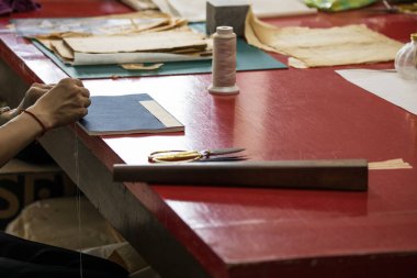 Pekin, Çin - 01 Haziran 2019: Geleneksel Çince kitap ve kaligrafi restoratörü laboratuvarı. Usta eller iş başında. Yakın plan..