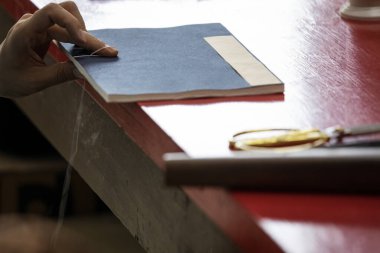 Pekin, Çin - 01 Haziran 2019: Geleneksel Çince kitap ve kaligrafi restoratörü laboratuvarı. Usta eller iş başında. Yakın plan..