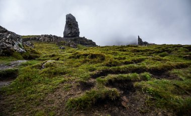 Iskoçya 'daki Skye Adası 'ndaki Storr 'ın yaşlı adamı. Sisli bulutlarla dağ manzarası.