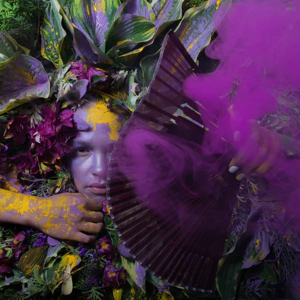 Retrato feminino em estilo conto de fadas rodeado de plantas e flores naturais . — Fotografia de Stock