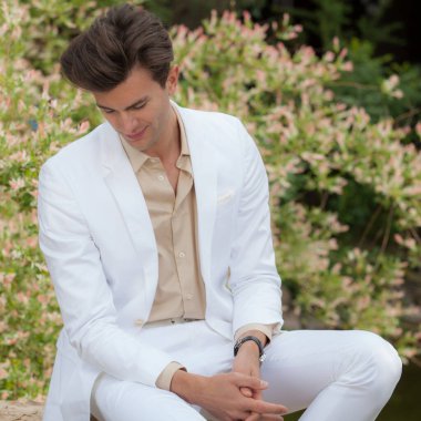 Dışarıda poz veren zarif yakışıklı genç adam..