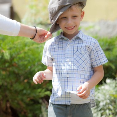 Dışarıda sevimli sarı saçlı bir çocuk oynuyor..