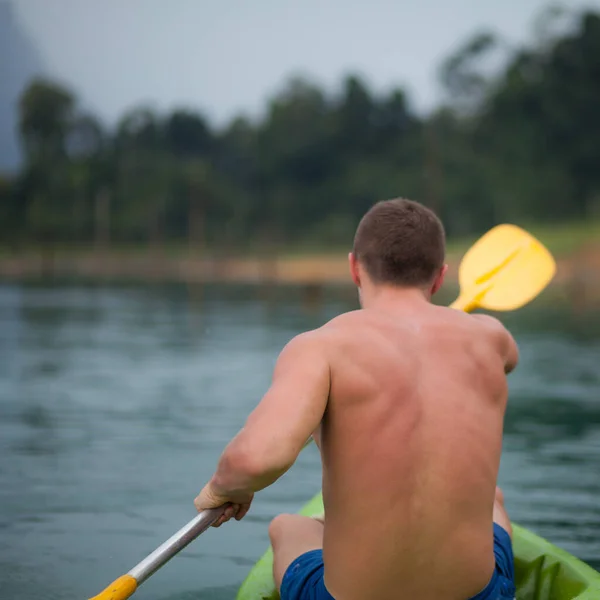 Mladý sportovní muž je kajak v jezeře. — Stock fotografie