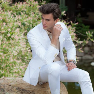 Dışarıda poz veren zarif yakışıklı genç adam..