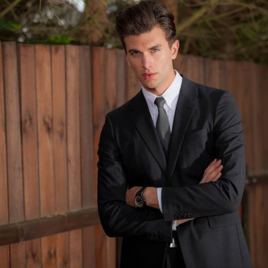 Dışarıda poz veren zarif yakışıklı genç adam..