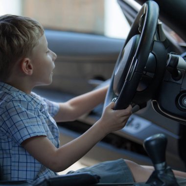 Dışarıda sevimli sarı saçlı bir çocuk oynuyor..