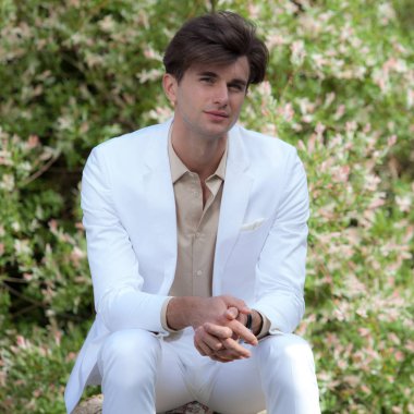 Dışarıda poz veren zarif yakışıklı genç adam..