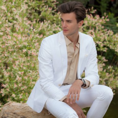 Dışarıda poz veren zarif yakışıklı genç adam..