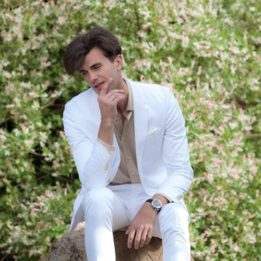 Dışarıda poz veren zarif yakışıklı genç adam..