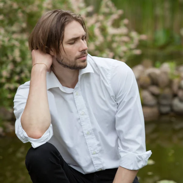 Junge elegante hübsche Mann posiert außerhalb. — Stockfoto