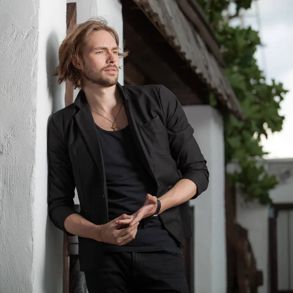 Junge elegante hübsche Mann posiert außerhalb. — Stockfoto