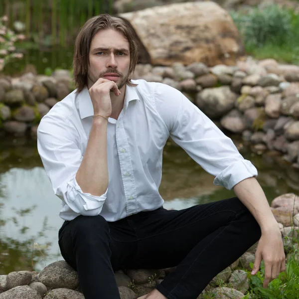 Junge elegante hübsche Mann posiert außerhalb. — Stockfoto