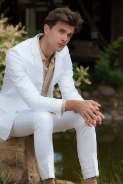 Dışarıda poz veren zarif yakışıklı genç adam..