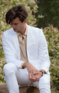 Dışarıda poz veren zarif yakışıklı genç adam..