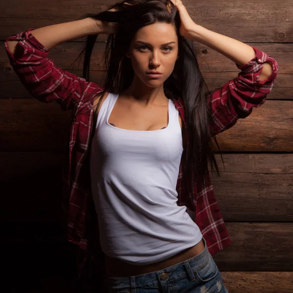 Portret van mooi jong meisje op houten achtergrond. — Stockfoto