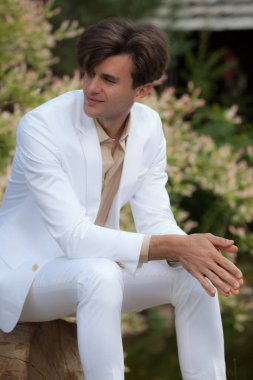 Dışarıda poz veren zarif yakışıklı genç adam..