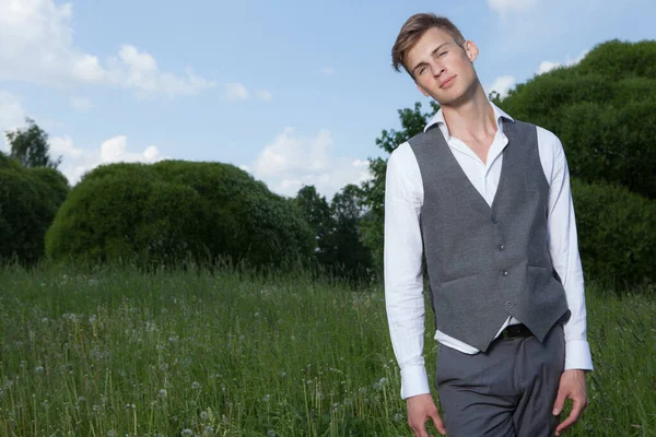 Junge elegante hübsche Mann posiert außerhalb. — Stockfoto