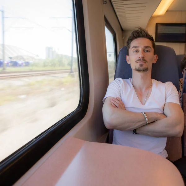 Jonge knappe man rijdt in een trein. — Stockfoto