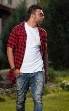 Dışarıda poz veren zarif yakışıklı genç adam..