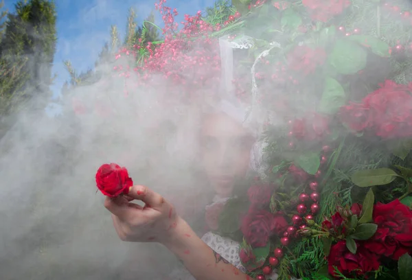 Vrouwelijk portret in sprookjesachtige stylization omgeven met natuurlijke bloemen. — Stockfoto