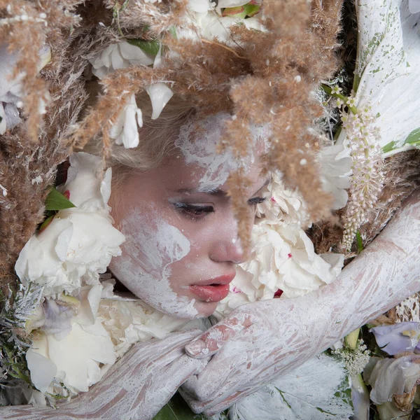 Retrato feminino em estilo conto de fadas rodeado de plantas e flores naturais . — Fotografia de Stock