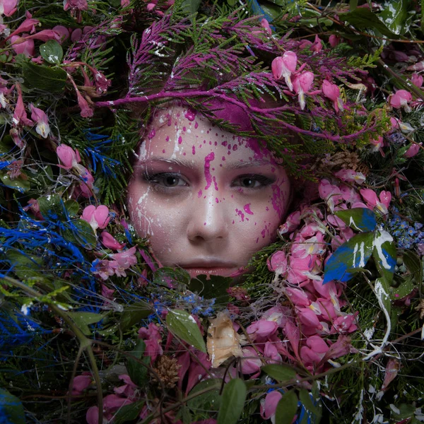 Female portrait in fairy tale stylisation surrounded with natural plants and flowers. — Stock Photo, Image