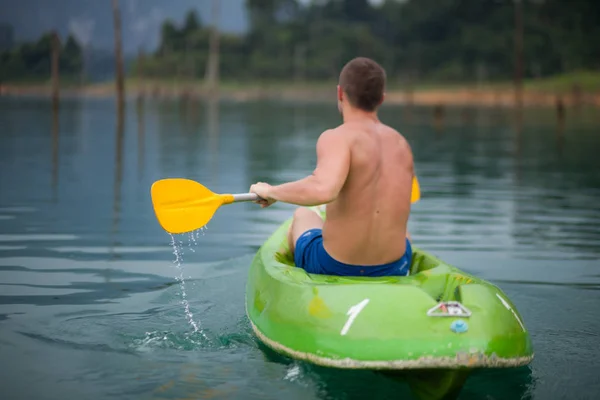Mladý sportovní muž je kajak v jezeře. — Stock fotografie