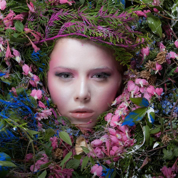 Kvinnelig portrett i eventyrlig stilisering omgitt av naturlige planter og blomster . – stockfoto