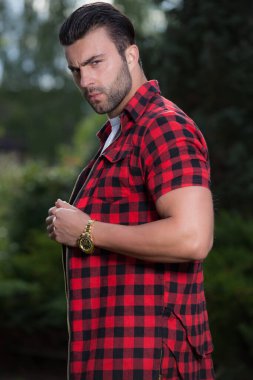 Dışarıda poz veren zarif yakışıklı genç adam..