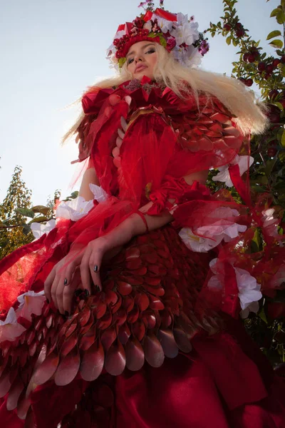 Sensueel blond meisje in fantasie rood sprookje stylization in appelpark. — Stockfoto