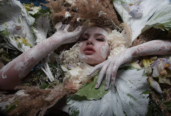 Portret kobiety w bajkowej stylizacji otoczonej naturalnymi roślinami i kwiatami. — Zdjęcie stockowe