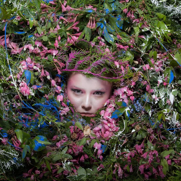 Vrouwelijk portret in sprookjesachtige stijl omgeven door natuurlijke planten en bloemen. — Stockfoto