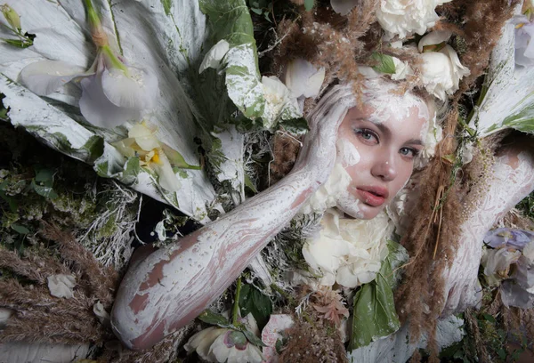 Portret kobiety w bajkowej stylizacji otoczonej naturalnymi roślinami i kwiatami. — Zdjęcie stockowe