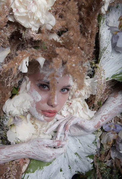 Vrouwelijk portret in sprookjesachtige stijl omgeven door natuurlijke planten en bloemen. — Stockfoto