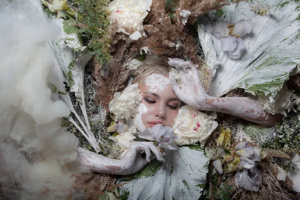 Retrato feminino em estilo conto de fadas rodeado de plantas e flores naturais . — Fotografia de Stock