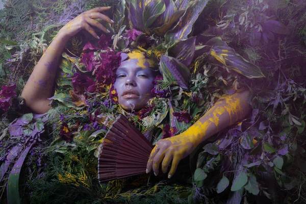 Retrato feminino em estilo conto de fadas rodeado de plantas e flores naturais . — Fotografia de Stock