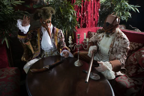 Actors in Steam punk masks and antique costumes indoor.