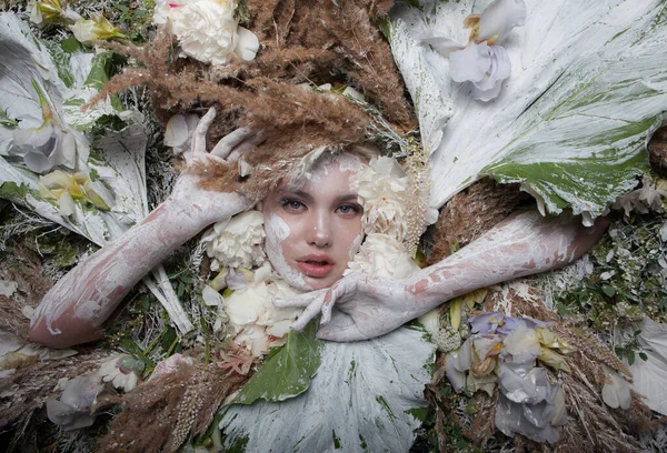 Portret kobiety w bajkowej stylizacji otoczonej naturalnymi roślinami i kwiatami. — Zdjęcie stockowe