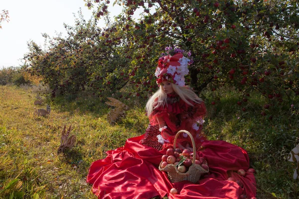 Sensuale ragazza bionda in fantasia rosso fiaba stilizzazione nel parco delle mele . — Foto Stock