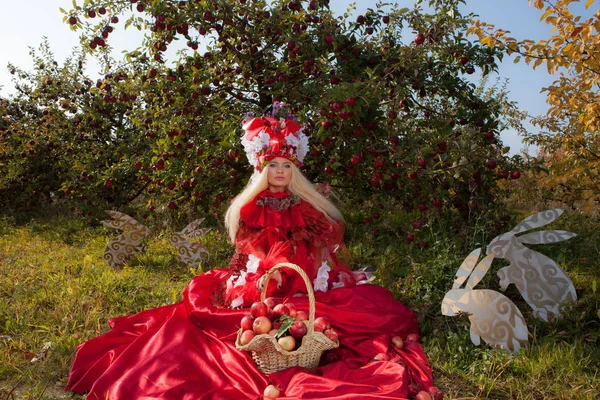 在苹果园，性感金发姑娘在幻想中的红色童话风格化. — 图库照片
