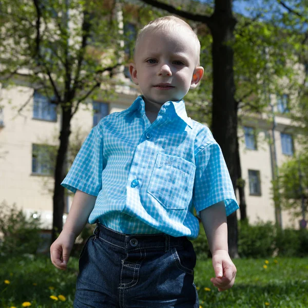 Netter blonder Junge spielt draußen. — Stockfoto